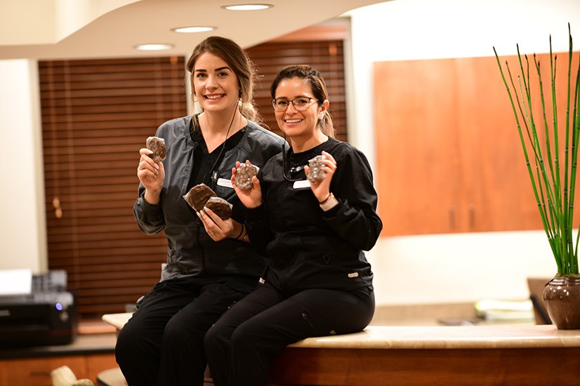 Two employees smiling in Wichita Family Dental office, reflecting a positive workplace culture.