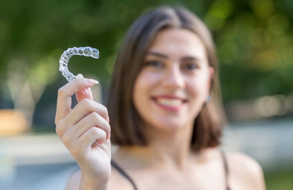 woman holding a clear Invisalign aligner during orthodontic consultation at Wichita Family Dental in Wichita, KS