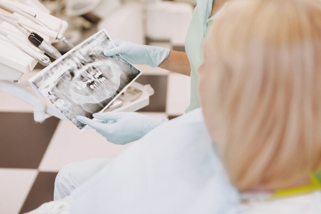 Dentist reviewing X-rays and discussing treatment options for a damaged tooth with a patient.